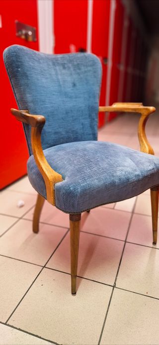 Silla azul de tela con brazos de madera