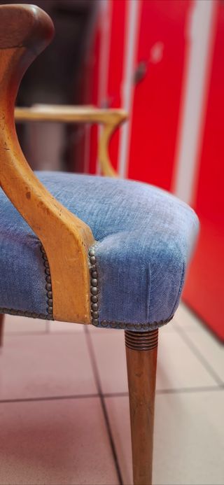 Silla azul de tela con brazos de madera