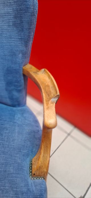 Silla azul de tela con brazos de madera