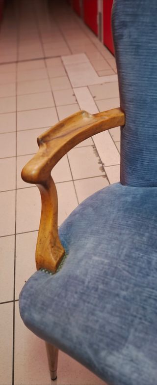 Silla azul de tela con brazos de madera