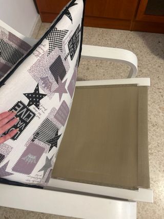 Hamaca de madera con cojines y cortinas a juego.