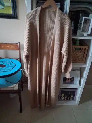 Vestido de punto beige sin mangas y abrigo.