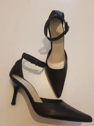 Zapatos de tacón negros con pulsera al tobillo.