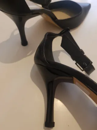 Zapatos de tacón negros con pulsera al tobillo.