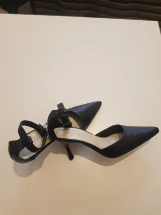 Zapatos de tacón negros con pulsera al tobillo.