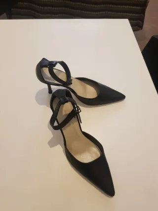 Zapatos de tacón negros con pulsera al tobillo.