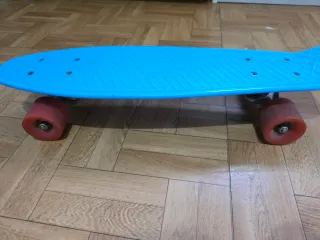 Monopatín azul con ruedas rojas