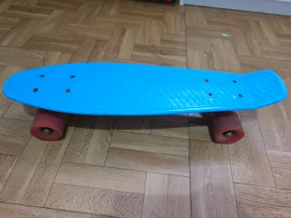 Monopatín azul con ruedas rojas