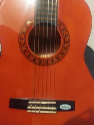 Guitarra española roja con funda
