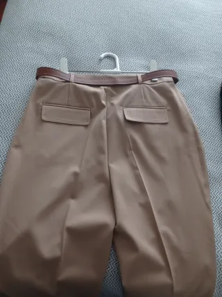 Pantalónes rectos, beige y negro con cinturón.