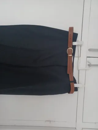 Pantalónes rectos, beige y negro con cinturón.