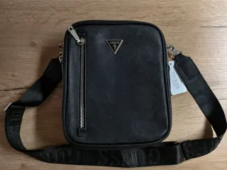 Bandolera Guess gris monograma.