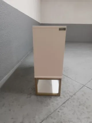 Armario de baño blanco con patas  doradas.