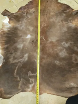 Alfombra de piel marrón y blanca