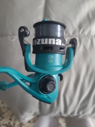 Caña de pesca y carrete turquesa