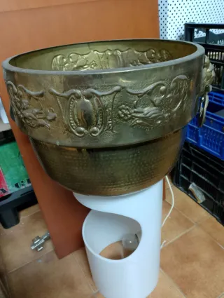 Macetero de metal dorado con leones