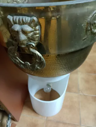 Macetero de metal dorado con leones