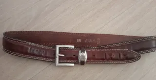 Cinturón de cuero marrón con hebilla plateada.