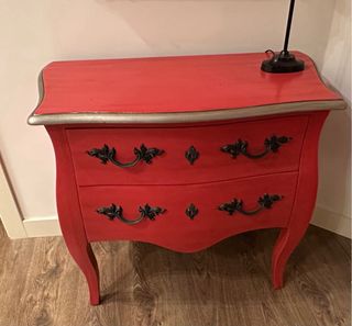 Cómoda roja con detalles plateados