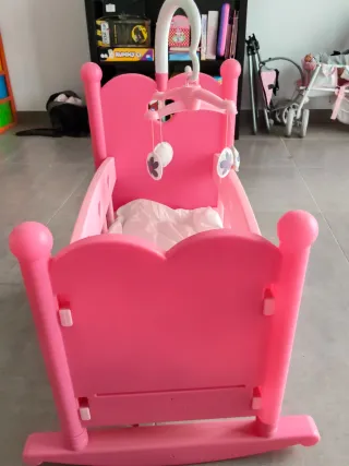 Cuna de muñeca rosa con móvil