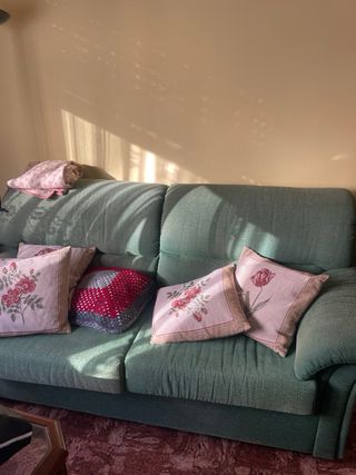 Sofá verde de tela.
