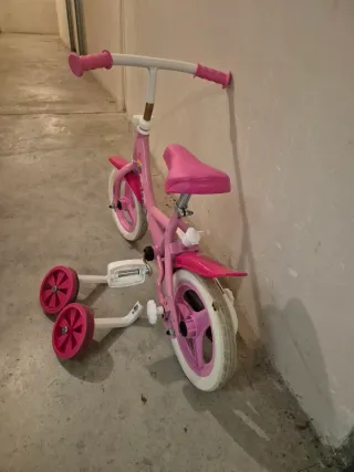 Bicicleta infantil rosa con ruedines
