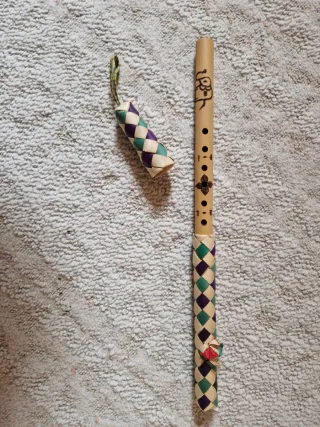 Flauta de bambú artesanal con funda trenzada.