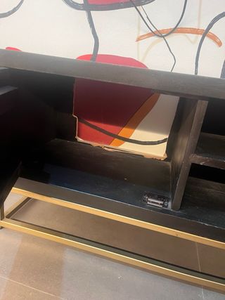 Mueble TV negro y dorado con diseño geométrico