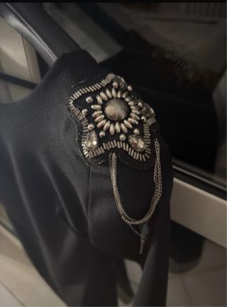 Vestito nero con decorazioni sulle spalle