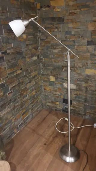 Lámpara de pie metálica plateada.
