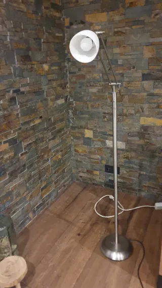 Lámpara de pie metálica plateada.