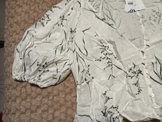 Blusa blanca con estampado floral negro