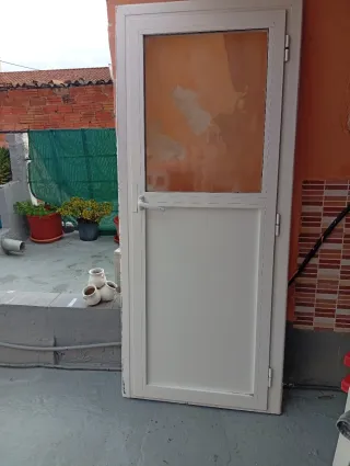 Puerta blanca con cristalde aluminio con marco