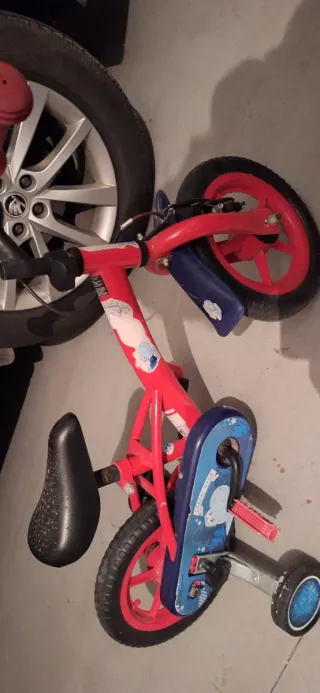 Bicicleta infantil roja con ruedines