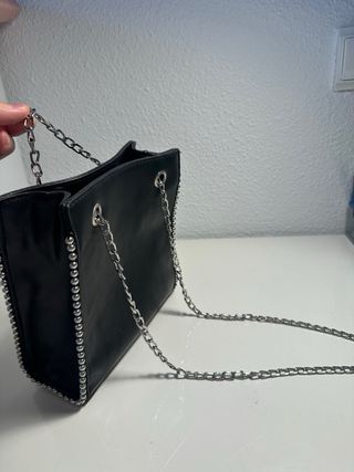 Bolso negro con tachuelas y cadena