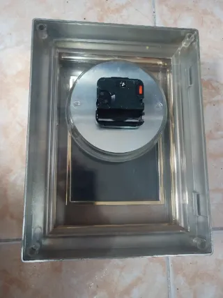 Reloj de mesa dorado con portafotos