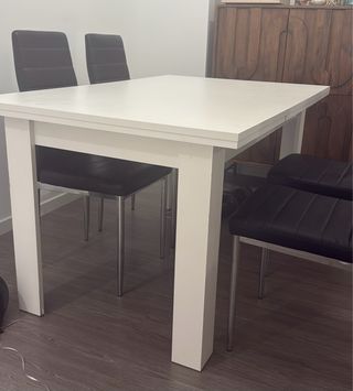 Mesa blanca con 4 sillas negras