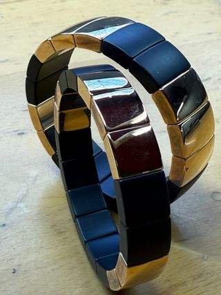 Pulseras de cerámica negra y baño de oro.