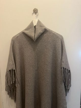 Poncho gris con cuello alto y flecos