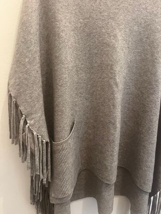 Poncho gris con cuello alto y flecos