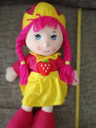 Muñeca de trapo con pelo rosa y vestido de fresa