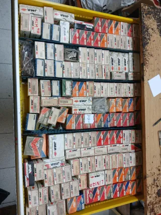 Banco de trabajo metálico amarillo con contenido.