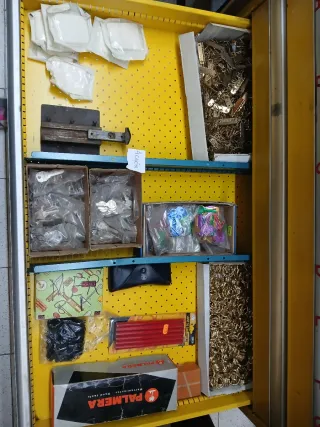 Banco de trabajo metálico amarillo con contenido.