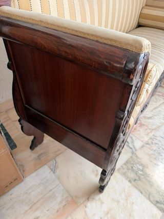 Banco antiguo de madera tapizado.