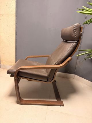 Butaca de piel marrón con estructura de madera