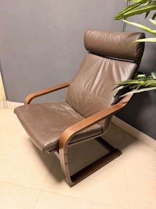 Butaca de piel marrón con estructura de madera