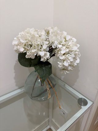 Jarrón de cristal con flores blancas