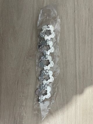 Pulsera plateada con diseño de flor