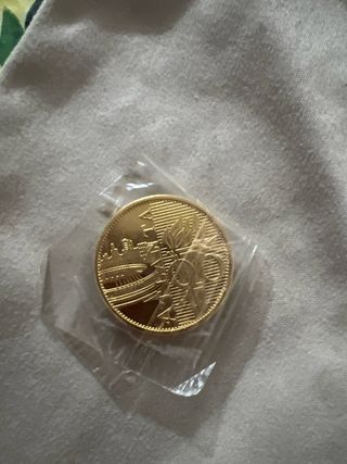 Moneda dorada con diseño de edificio