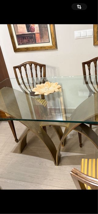 Mesa de cristal y bronce con diseño curvo .